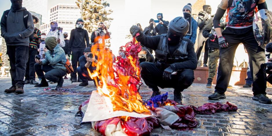 Manifestantes del grupo “Anti-Fascist Collation” prenden fuego durante la toma de posesión, en Denver.