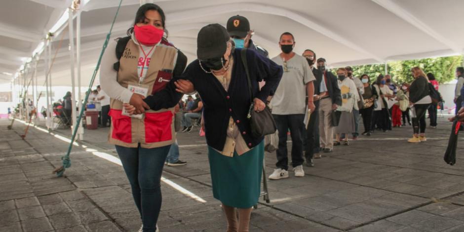Una mujer de edad avanzada camina en las inmediaciones del centro de vacunación contra COVID-19, ubicado en el Palacio Municipal de Nezahualcóyotl