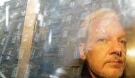 En esta imagen del 1 de mayo de 2019, las fachadas de los edificios se reflejan en una ventana mientras el fundador de WikiLeaks Julian Assange es retirado de una corte en Londres.