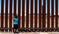 Un niño observa a través del muro fronterizo, en la frontera México-EU, en 2019.