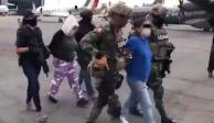 Elementos militares trasladan a Guadalupe "V" y a su pareja (detrás) tras ser detenidas.