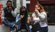 Habitantes de la Ciudad de México comen papas fritas en la calle