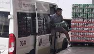 Un hombre es captado cuando descarga paquetes de cerveza de una camioneta del DIF-Puebla.