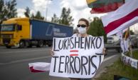 Una manifestante lleva un cartel que dice "Lukashenko = Terrorista" en una protesta contra el presidente bielorruso.