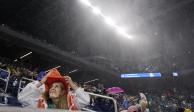 Una aficionada se cubre de la lluvia en el estadio Louis Armstrong, durante el partido entre 
Kevin Anderson y Diego Schwartzman en la segunda ronda del US Open.