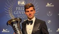 Max Verstappen sostiene el trofeo que se le entregó tras coronarse en la F1.