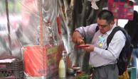 Hombre come tacos en comercio de la Ciudad de México.