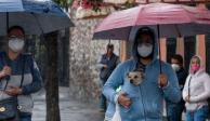 Dos capitalinas se cubren de las lluvias junto con su perro en calles de la CDMX.