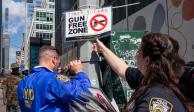Los oficiales de policía de la ciudad de Nueva York instalan carteles que dicen "zona libre de armas" en Times Square a medida que entran en vigencia nuevas leyes de armas,