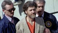 Theodore "Ted" Kaczynski es escoltado a su auto afuera de una corte federal en Helena, Montana, el 4 de abril de 1996