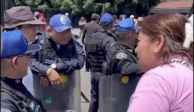 Una aficionada le reclama a la policía por haber dejado entrar a tres personas que no se formaron para comprar boletos del América vs Chivas en el Estadio Azteca.