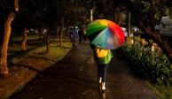 Una mujer camina con su paraguas sobre Reforma durante las últimas horas de luz de día. 
FOTO: GALO CAÑAS/CUARTOSCURO.COM