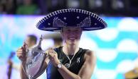 Iga Swiatek, de Polonia, sostiene el trofeo que la acredita como campeona del torneo que cierra la temporada, las Finales de la WTA, después de derrotar a Jessica Pegula, de Estados Unidos, en Cancún