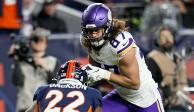 El tight end de los Minnesota Vikings T.J. Hockenson corre tras atrapar un balón frente al safety de los Denver Broncos Kareem Jackson en la NFL