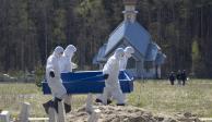 Cavadores de tumbas llevan un ataúd mientras entierran a una víctima de COVID-19 en un cementerio en Kolpino, en San Petersburgo, Rusia, el 10 de mayo de 2020.