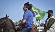 El presidente de Brasil, Jair Bolsonaro, monta un caballo de la policía para saludar a los partidarios reunidos afuera del palacio presidencial en Brasilia, el domingo 31 de mayo de 2020.