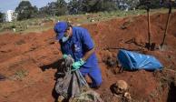 Un trabajador exhuma el cuerpo de una persona enterrada hace tres años en el cementerio de Vila Formosa.
