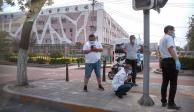 Varias personas utilizan mascarillas para protegerse del nuevo coronavirus en una calle afuera del mercado mayorista de alimentos Xinfadi en Beijing.