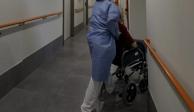 Un técnico sanitario del centro de mayores Casablanca Villaverde lleva a un residente a su habitación.