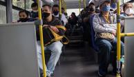 Habitantes de la capital portan cubrebocas mientras viajan en un autobús de transporte público con todos los asientos ocupados, ayer.