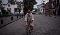 Un hombre circula en bicicleta y con cubrebocas en Coyoacán.