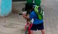 Niño le pone cubrebocas a su perrito para salir en bici
