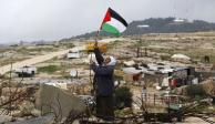 Un hombre cuelga una bandera palestina en el sur de Cisjordania, en enero.