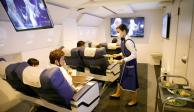 Personal vestido como asistente de vuelo sirve comidas a los clientes de First Airlines, que brinda experiencias de vuelo de realidad virtual.
