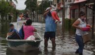 Familias afectadas en Nacajuca recuperan algunas pertenencias para abandonar sus casas tras las inundaciones.