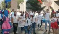 Trabajadores de salones de fiestas infantiles marchan hacia la Secretaría de Salud estatal.