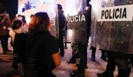 Mujeres protestan frente a policías luego de los actos de represión contra una movilización en Cancún.