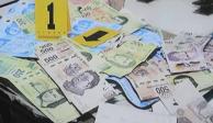 Autoridades presentan billetes falsos decomisados.