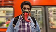 Un joven posa con un cubrebocas decorativo, después de transbordar en la Línea 3 del Metro, en octubre.