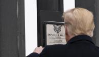 El expresidente de EU, Donald Trump, firma una placa en el muro, el 12 de enero pasado.