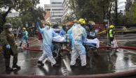 Trabajadores de salud ayudan a evacuar a un paciente con COVID-19 luego de un incendio en el hospital San Borja en Santiago de Chile.
