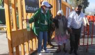Una brigadista recibe en la entrada del centro de vacunación a una mujer de 80 años, en Xochimilco.