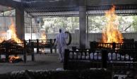 Un empleado supervisa la cremación de las víctimas de un incendio, ayer, en India.
