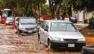 Automóviles transitan en una calle anegada, en el centro de Metepec, ayer.