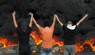 Manifestantes palestinos miran llantas en llamas durante una protesta por la tensión en Jerusalén e Israel&nbsp;