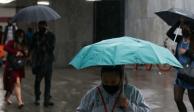 Personas con paraguas que salen la estación Insurgentes del Metro de la CDMX,
