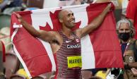 Damian Warner, con la bandera de Canadá, luego de obtener la presea áurea en el decatlón en Tokio 2020.