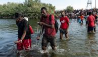 Migrantes que buscan asilo en EU caminan sobre el río Bravo, en Ciudad Acuña.