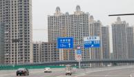 Los vehículos pasan por edificios residenciales sin terminar del Evergrande Oasis, un complejo de viviendas desarrollado por Evergrande Group, en Luoyang, China, el 16 de septiembre de 2021. Fotografía tomada el 16 de septiembre de 2021
