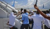 Haitianos deportados intentan abordar de nuevo el avión en el que llegaron a Puerto Príncipe, ayer.