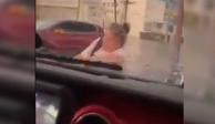 Mujer se aferra a cofre de camioneta para salir de una inundación  en Guadalajara