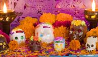 Ofrenda de Día de Muertos con elementos como calaveras, flor de cempasúchil, veladoras y papel picado.
