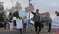 Padres y menores protestan en contra de los mandatos para hacer obligatoria la vacunación.