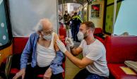 Personal sanitario vacuna a pasajeros en un tren, en Alemania.