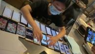 Empleada de restaurante en China trabaja con 20 celulares casi a la vez