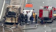 Bomberos y trabajadores forenses inspeccionan la escena del choque de un autobús que, según las autoridades, mató al menos a 45 personas en una carretera cerca de la aldea de Bosnek, en el oeste de Bulgaria